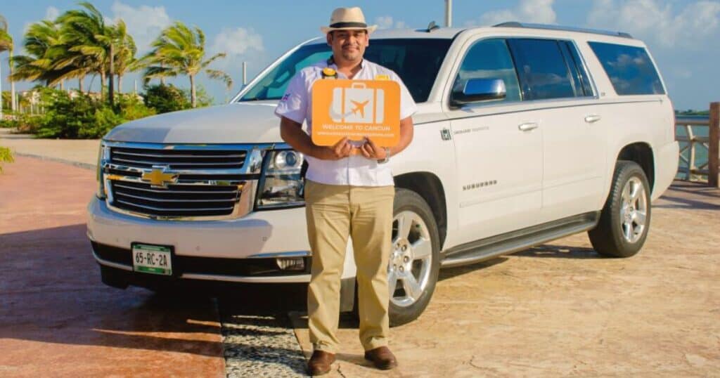 man holding sign in front of a brand new SUV from the best cancun to tulum shuttle service