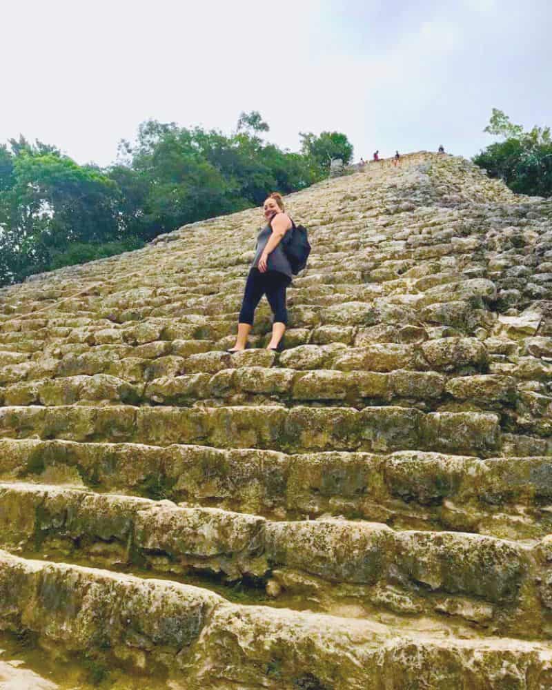 woman climbing coba pyramid in mexico
