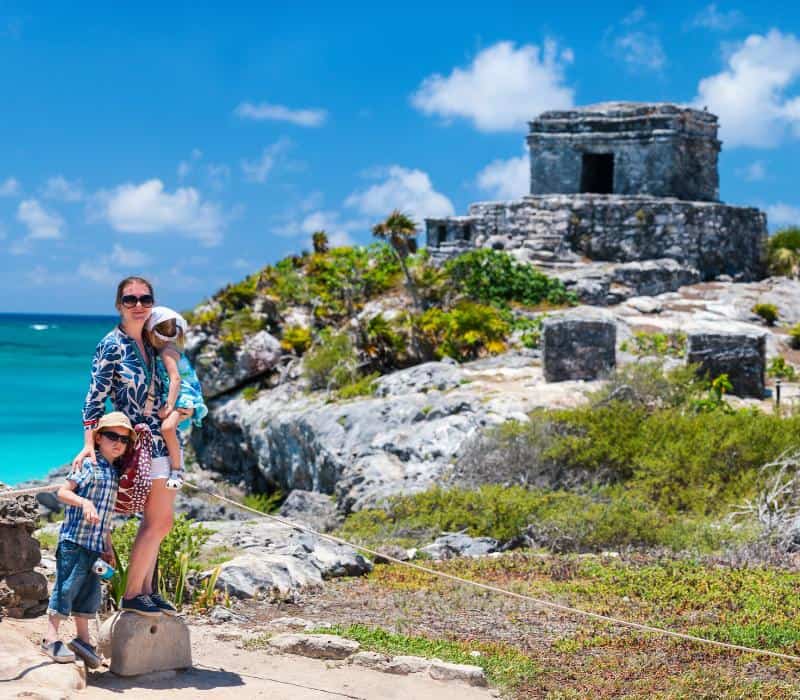mother with two kids posing in front of Tulum ruins
