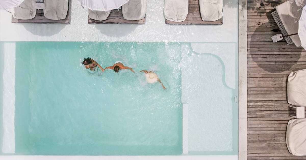 two friends swimming in the pool - Tulum luxury resorts