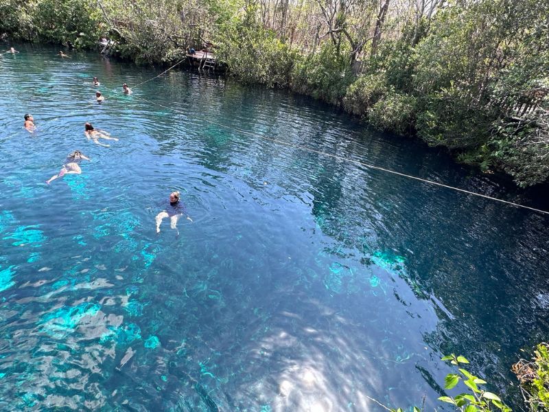 people swimming in cenote carwash tulum mexico